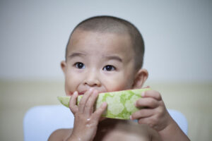 Baby eating melon